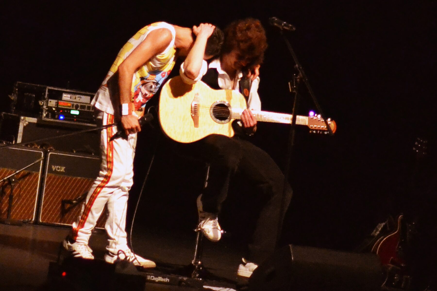 Freddie and Brian leaning in together during an acoustic moment